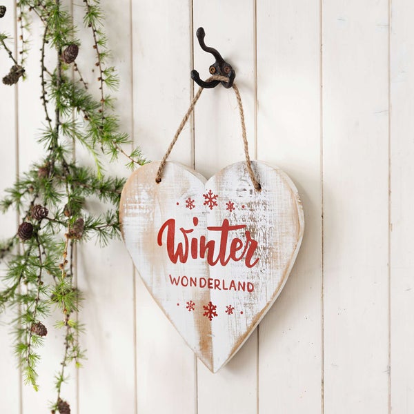 Herzförmiges Deko Schild mit der Aufschrift Winter Wonderland hängt an einem Haken.