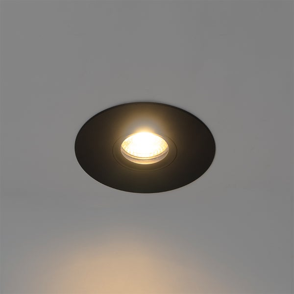 Runder Einbaustrahler in Schwarz, im eingeschalteten Zustand mit warmweißem Licht.