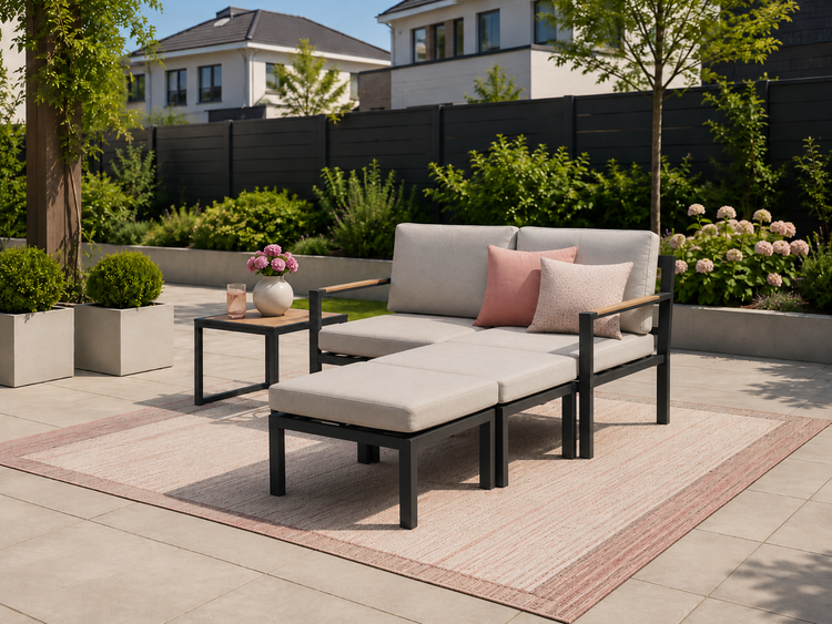 Modernes Garten-Lounge-Set aus Metall mit Polstern, bestehend aus einem Zweisitzer-Sofa, Hocker und Beistelltisch auf einer hellen Terrasse.