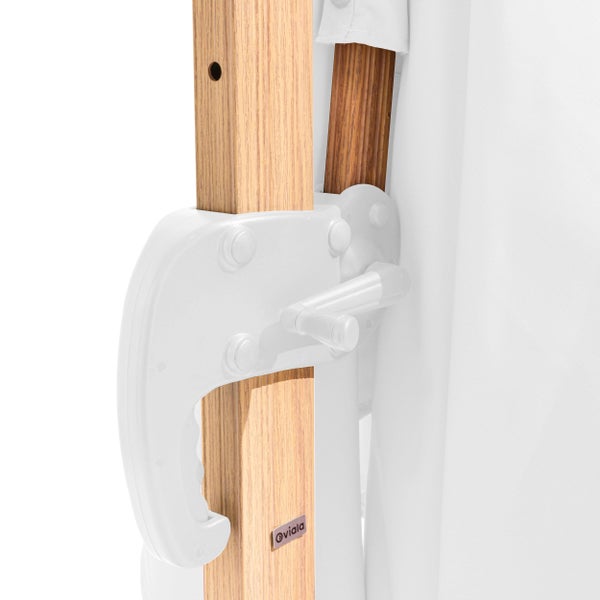 Nahaufnahme eines weißen Kurbelmechanismus an einem hölzernen Sonnenschirmmast mit weißem Stoff.