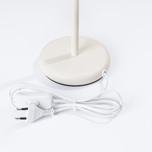 Detailansicht des Fußes einer Stehlampe mit Kabel und Stecker