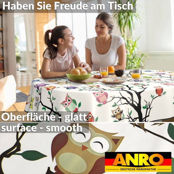 Mutter und Tochter am Tisch mit einer Tischdecke mit Eulenmuster und dem Anro Deutsche Manufaktur Logo.