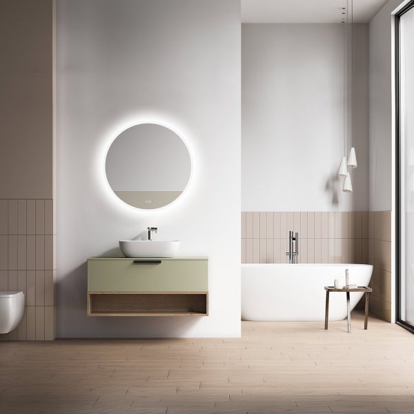 Modernes Badezimmer mit Waschtisch, Aufsatzwaschbecken, beleuchtetem Rundspiegel, freistehender Badewanne und hellen Fliesen an der Wand.