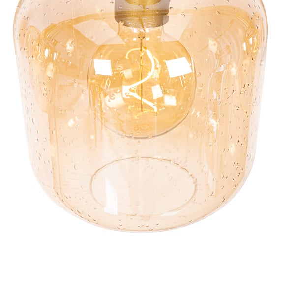 Nahaufnahme einer Pendelleuchte mit einem Schirm aus bernsteinfarbenem Glas und einer Glühbirne