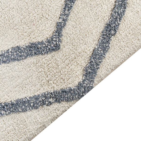 Nahaufnahme eines Hochflor-Teppichs mit strukturiertem Wellenmuster.