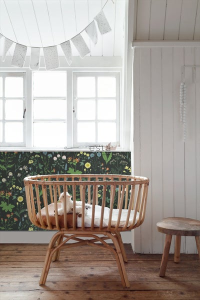 Babyzimmer mit Rattanwiege, Fenster und floraler Tapete