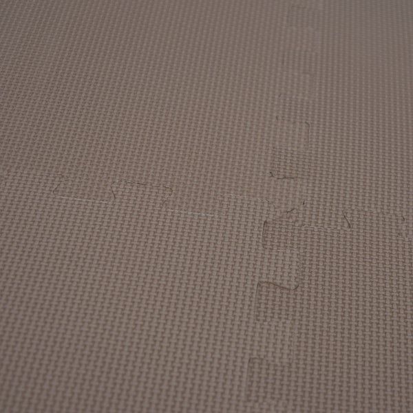 Nahaufnahme einer strukturierten Bodenschutzmatte mit ineinandergreifenden Puzzlekanten.