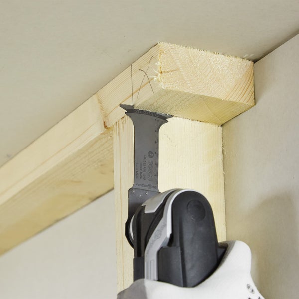 Bosch Logo. Multifunktionswerkzeug beim Schneiden eines Nagels in einem Holzstück.