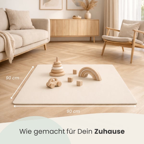 Quadratische Spielmatte mit den Maßen 90 mal 90 Zentimeter auf hellem Parkettboden in einem hellen Wohnzimmer mit Holzspielzeug.