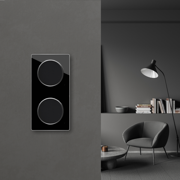 Moderner Doppellichtschalter in einem elegant eingerichteten Wohnzimmer mit Sessel und Stehlampe.