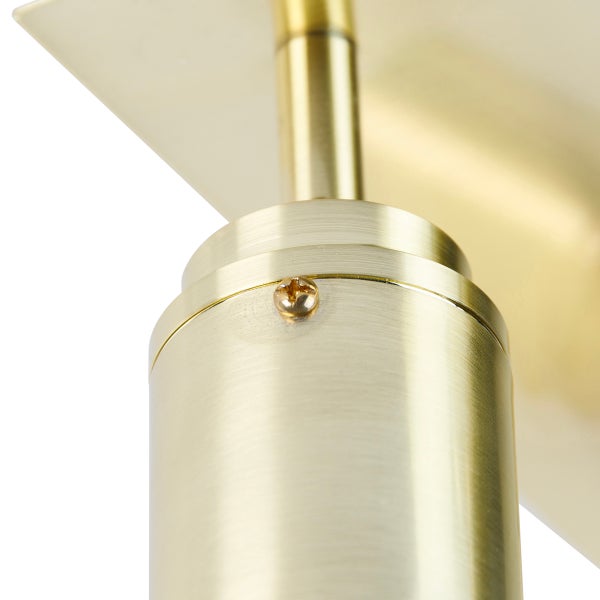 Detailaufnahme einer goldenen Wandleuchte mit Schraube