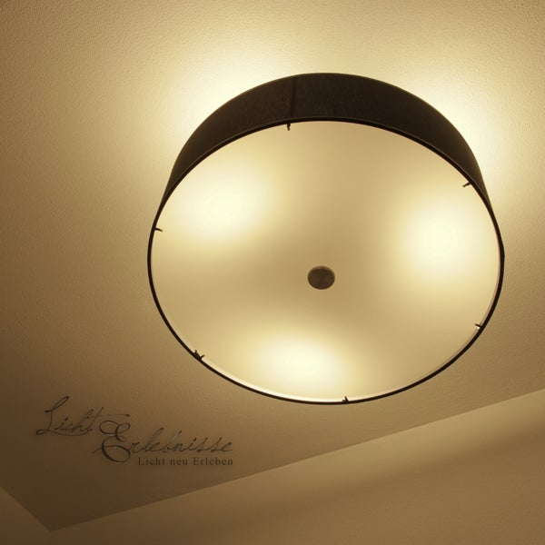 Runde Deckenleuchte mit Textilschirm und Diffusor zur gleichmäßigen Lichtverteilung an der Zimmerdecke.