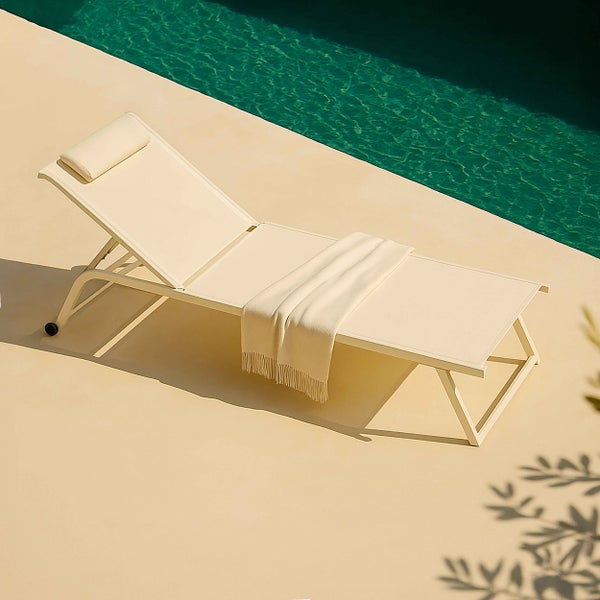 Moderne Gartenliege mit Rollen, verstellbarem Kopfteil, Kissen und Decke auf einer hellen Terrasse am Pool.