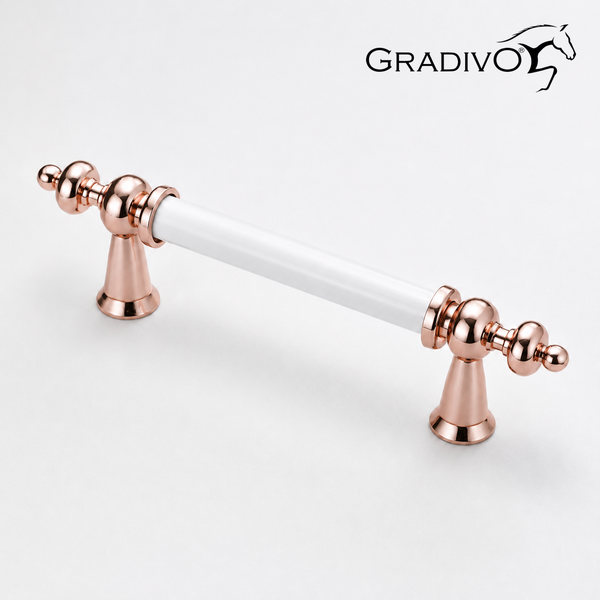 Möbelgriff mit weißem Keramikgriff und dekorativen Endstücken aus Metall in Roségold. Gradivo Logo.