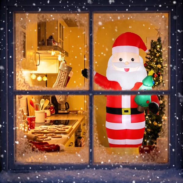 Aufblasbarer Weihnachtsmann als Dekoration vor einem weihnachtlich geschmückten Fenster mit Schneefall im Hintergrund.