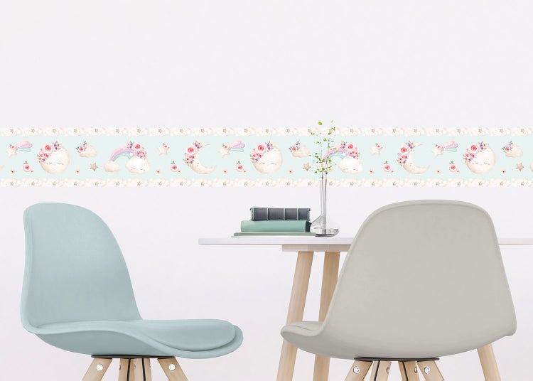Selbstklebende Bordüre für das Kinderzimmer mit Motiven von Mond, Regenbogen, Wolken und Blumen an einer Wand über einem Bett.