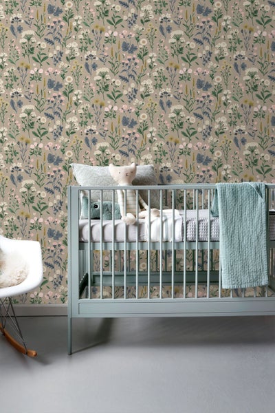 Vliestapete mit botanischem Blumenmuster in einem Kinderzimmer mit hellblauem Gitterbett und weißem Schaukelstuhl.