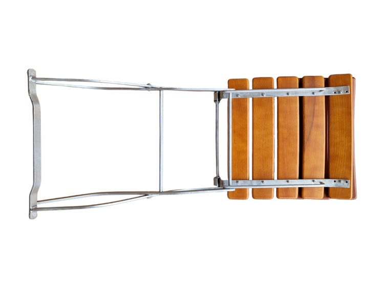 Klapphocker mit Sitzfläche aus Holzlatten und einem Gestell aus Metall.