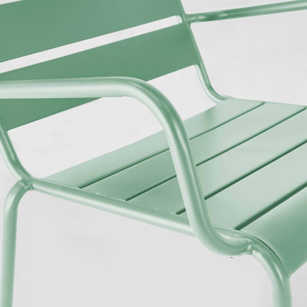 Nahaufnahme eines grünen Metallgartenstuhls mit Lattensitz und geschwungenen Armlehnen.