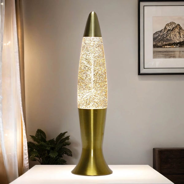 Goldfarbene Stehlampe mit Glitzerpartikeln auf einem Tisch