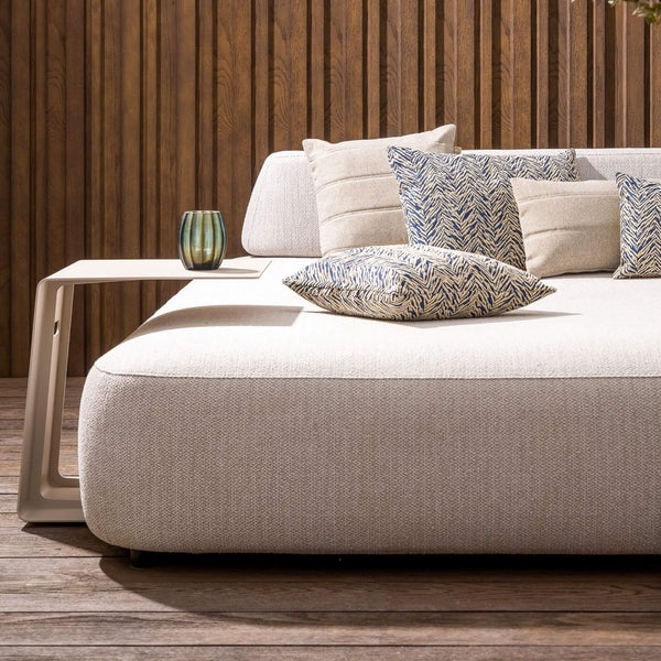 Gartensitzgruppe mit Couchtisch und dekorativen Kissen vor Holzwand