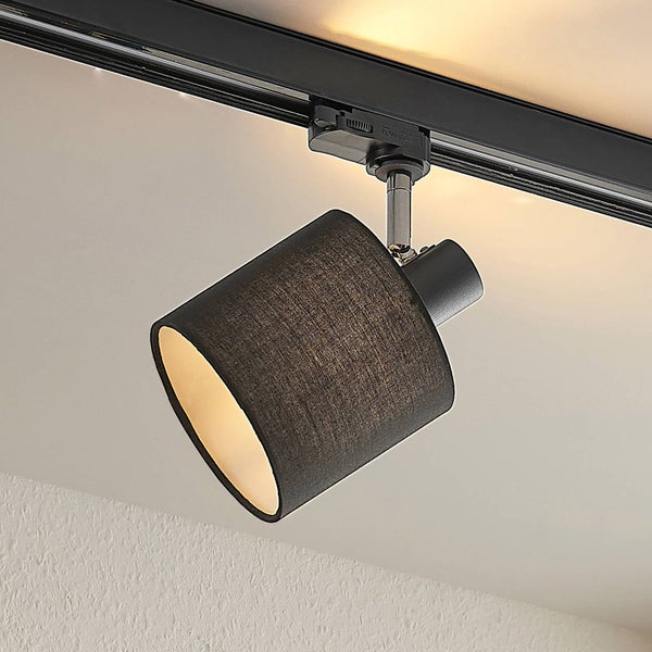Moderner Schienensystem-Strahler mit zylindrischem schwarzem Stoffschirm, montiert an einer schwarzen Deckenschiene.