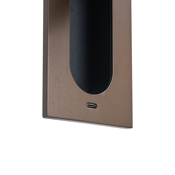 Detailansicht eines USB-C Ladeanschlusses an einer braunen Metalloberfläche.