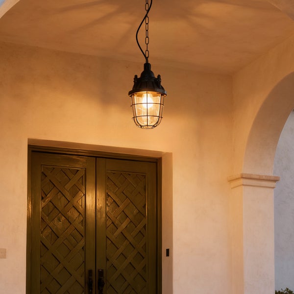 Hängelampe im Außenbereich mit Schutzgitter über einer Tür