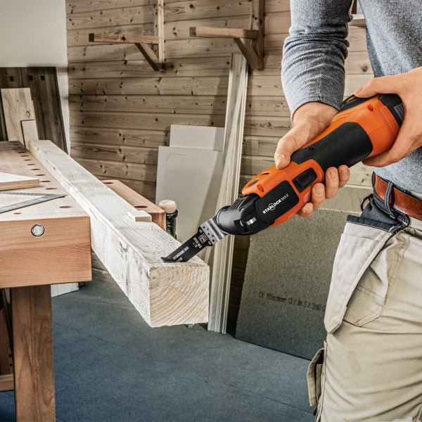 Multifunktionswerkzeug im Einsatz zum Schneiden eines Holzstücks auf einer Werkbank