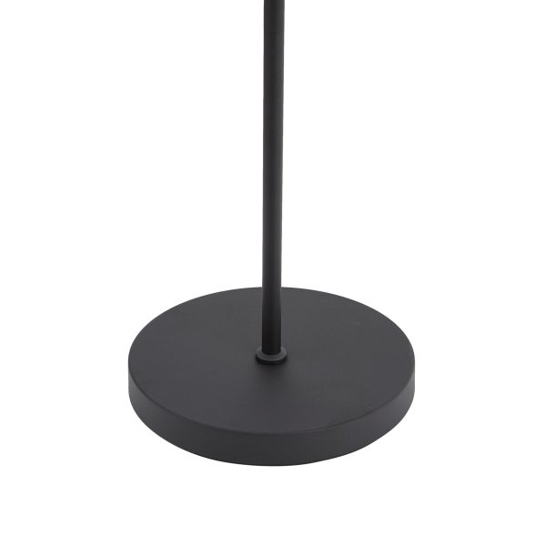 Nahaufnahme des runden, mattschwarzen Standfusses einer Lampe mit dünnem Gestell.