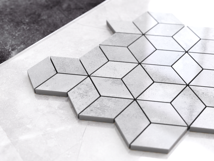 Geometrische Mosaikfliese in Rautenform mit dreidimensionalem Effekt und Steinoptik in Grau.