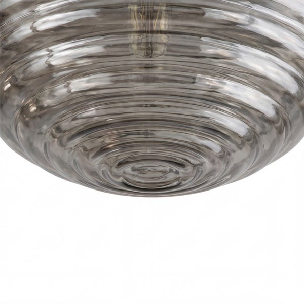 Nahaufnahme eines runden Lampenschirms aus Glas mit konzentrischer Rillenstruktur.