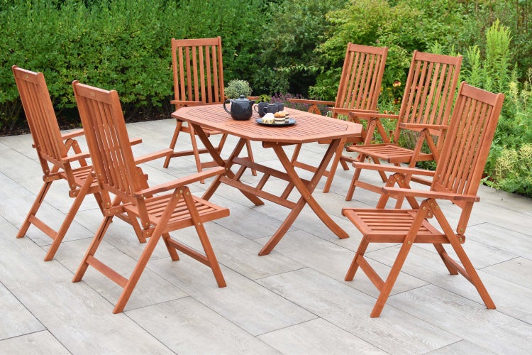 Gartenszene mit Holztisch und sechs Holzstühlen auf einer Terrasse