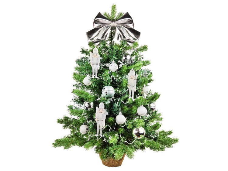 Künstlicher Weihnachtsbaum im Topf mit Kugeln, Nussknackerfiguren und einer Schleife als Weihnachtsdekoration.