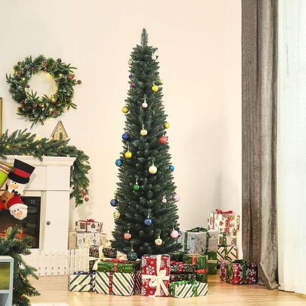 Schmaler künstlicher Weihnachtsbaum mit bunten Kugeln und vielen Geschenken in einem hellen Wohnzimmer neben einem weißen Kamin mit Kranz.