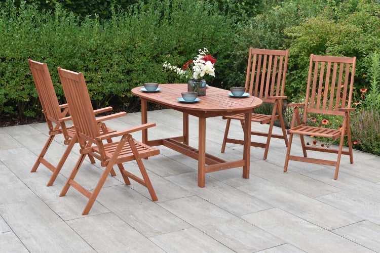 Gartenszene mit Holztisch und vier Holzstühlen auf einer Terrasse