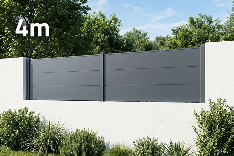 Moderne Sichtschutzwand aus Metall in vier Meter Laenge montiert auf einer weissen Gartenmauer im Aussenbereich.