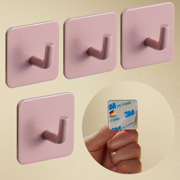 Set aus vier rosa selbstklebenden Wandhaken mit quadratischer Basis und 3M-Klebestreifen, entwickelt in Deutschland.