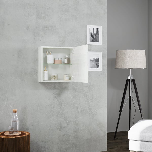 Badezimmer-Szene mit weißem Spiegelschrank, offen, mit Badutensilien an einer Betonwand