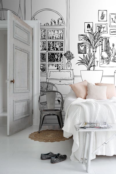 Wohnraum mit gezeichneter Tapete, Bett und Vintage-Dekorationen