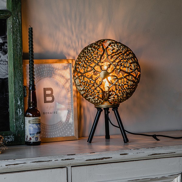 Dekorative Tischleuchte mit dreibeinigem Gestell und einem Lampenschirm in Kugelform