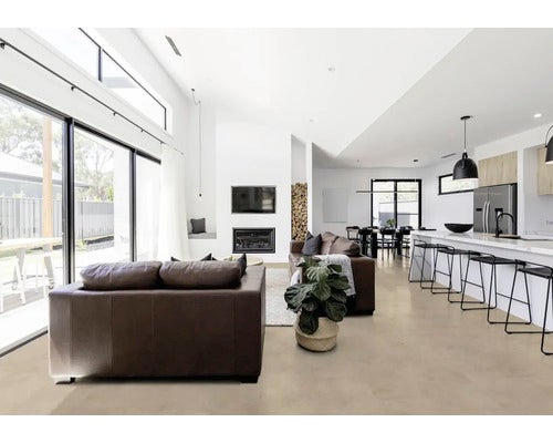 Helles Wohnzimmer mit Ledersofa, Esstisch und Küchenzeile in modernem Design.