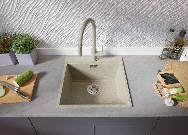 Spüle mit Armatur auf einer Küchentheke mit Gemüse und Küchenutensilien