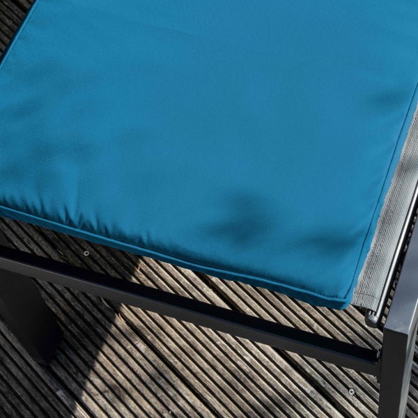 Detailaufnahme einer blauen Sitzauflage für Gartenmöbel aus wetterfestem Stoff.