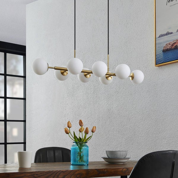 Moderne Pendelleuchte mit sieben Lampenschirmen in Kugelform über einem Esstisch.