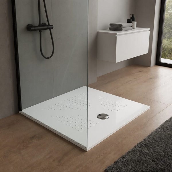 Quadratische, flache Duschwanne in Weiß mit strukturierter Oberfläche in einem modernen Badezimmer mit Glaswand und schwarzer Armatur.