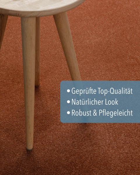 Rostroter Teppichboden mit einem Holzschemel, geprüft für Top-Qualität, natürlichen Look, robust und pflegeleicht.
