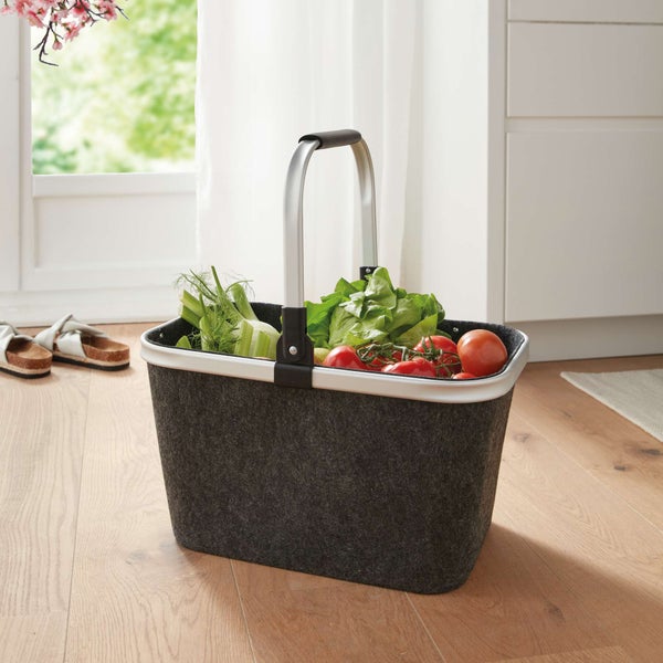 Einkaufskorb aus Filz mit Gemüse auf einem Holzboden