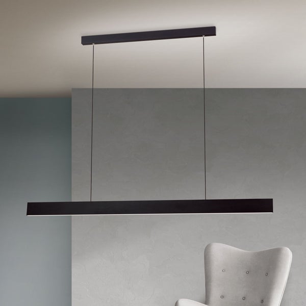 Moderne schmale LED Pendelleuchte mit linearer Form über einem Sessel im Innenraum.