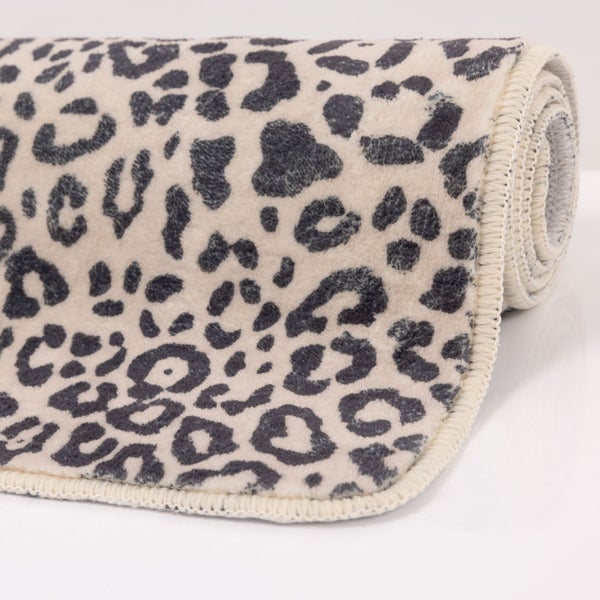 Aufgerollter Teppichläufer mit Leopardenmuster und gekettelter Kante.